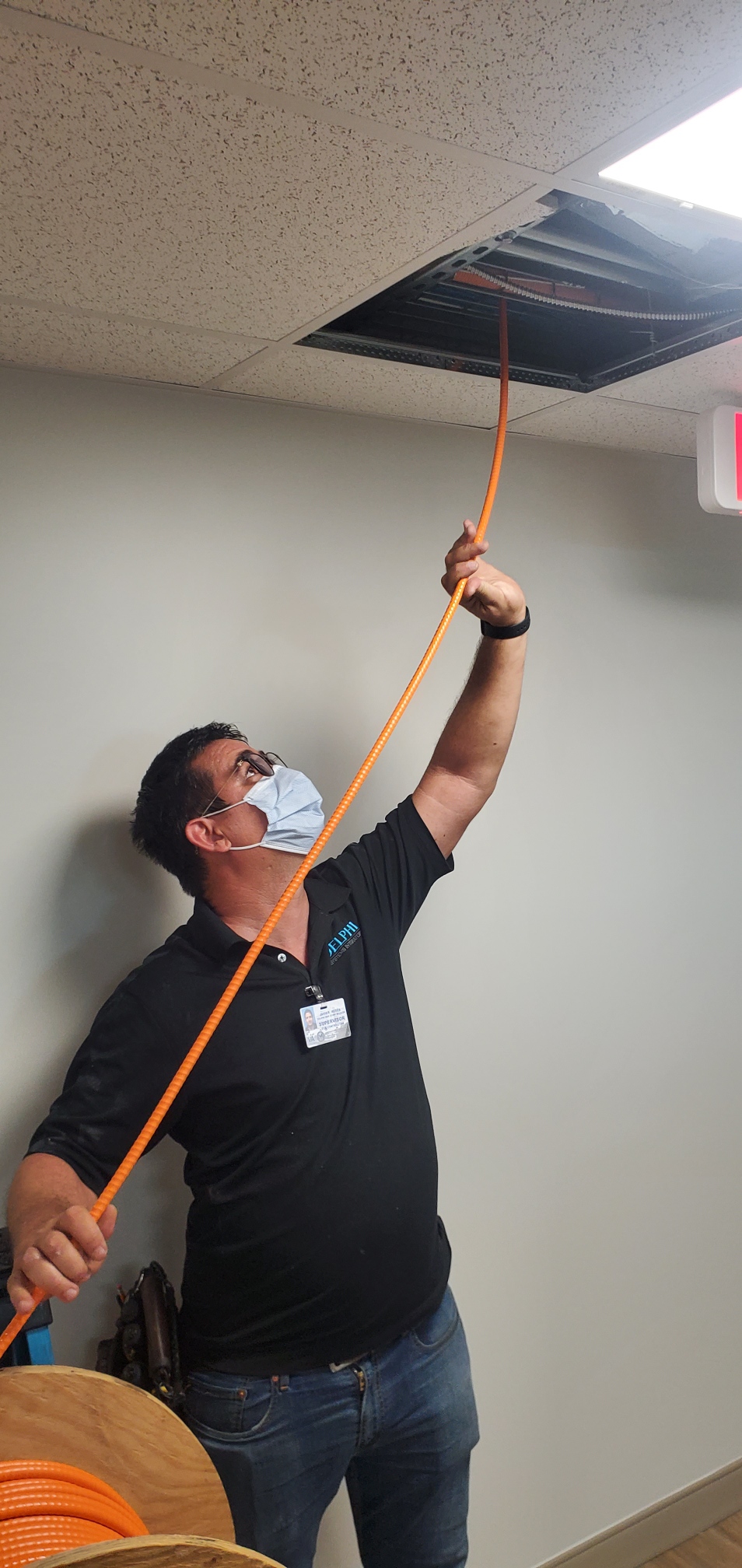 Technician routing cable in a finished space